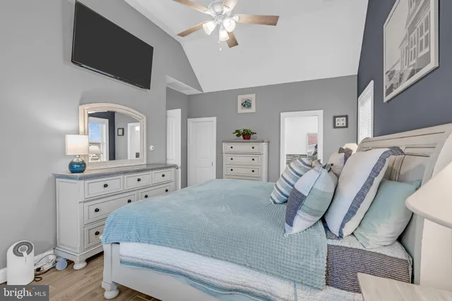 a bedroom with a bed and a flat tv screen on dresser