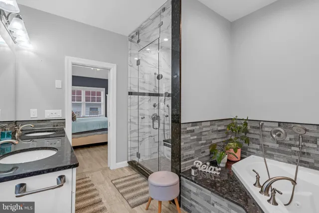 a bathroom with a granite countertop sink a toilet and shower