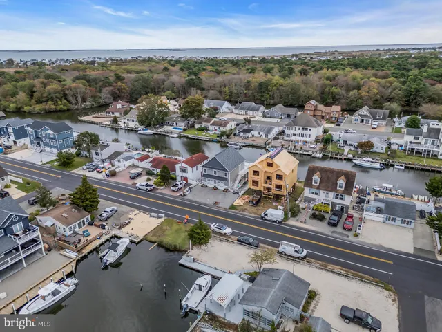 an aerial view of ocean and residential houses with outdoor space