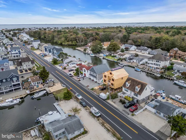 an aerial view of ocean and residential houses with outdoor space