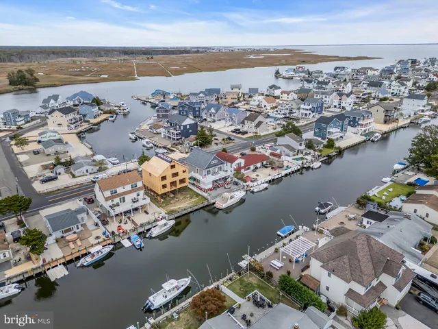 an aerial view of ocean and residential houses with outdoor space