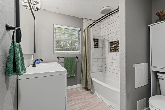 a bathroom with a sink a toilet and shower