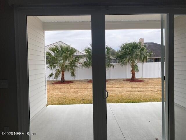 85236 Sandy Rdg Loop, Unit 26 Yulee, FL 32097 - Photo 15 of 17 a view of a living room with a floor to ceiling window and potted plants
