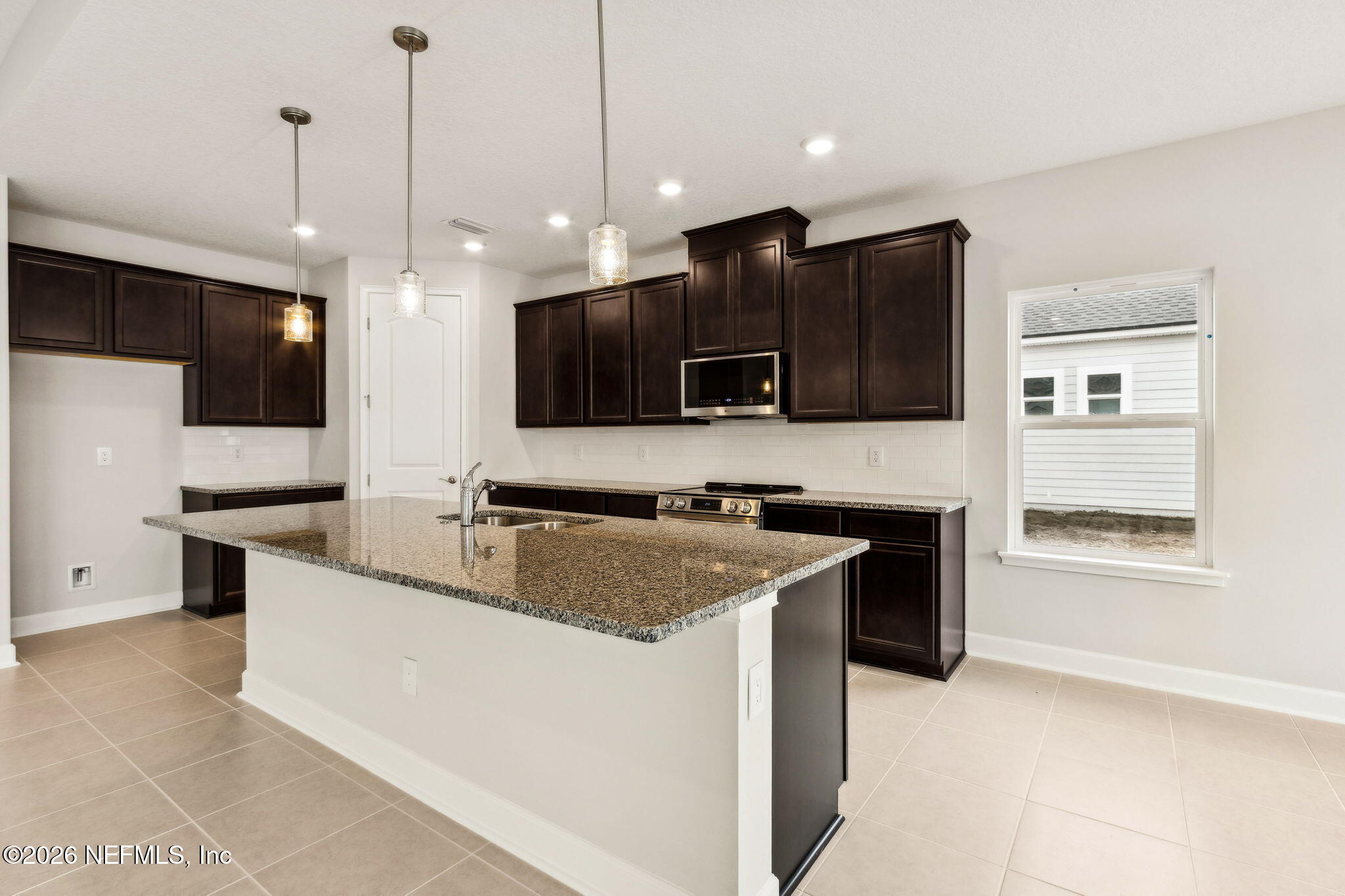 85236 Sandy Rdg Loop, Unit 26 Yulee, FL 32097 - Photo 4 of 17 a kitchen with stainless steel appliances granite countertop a sink a stove and a refrigerator