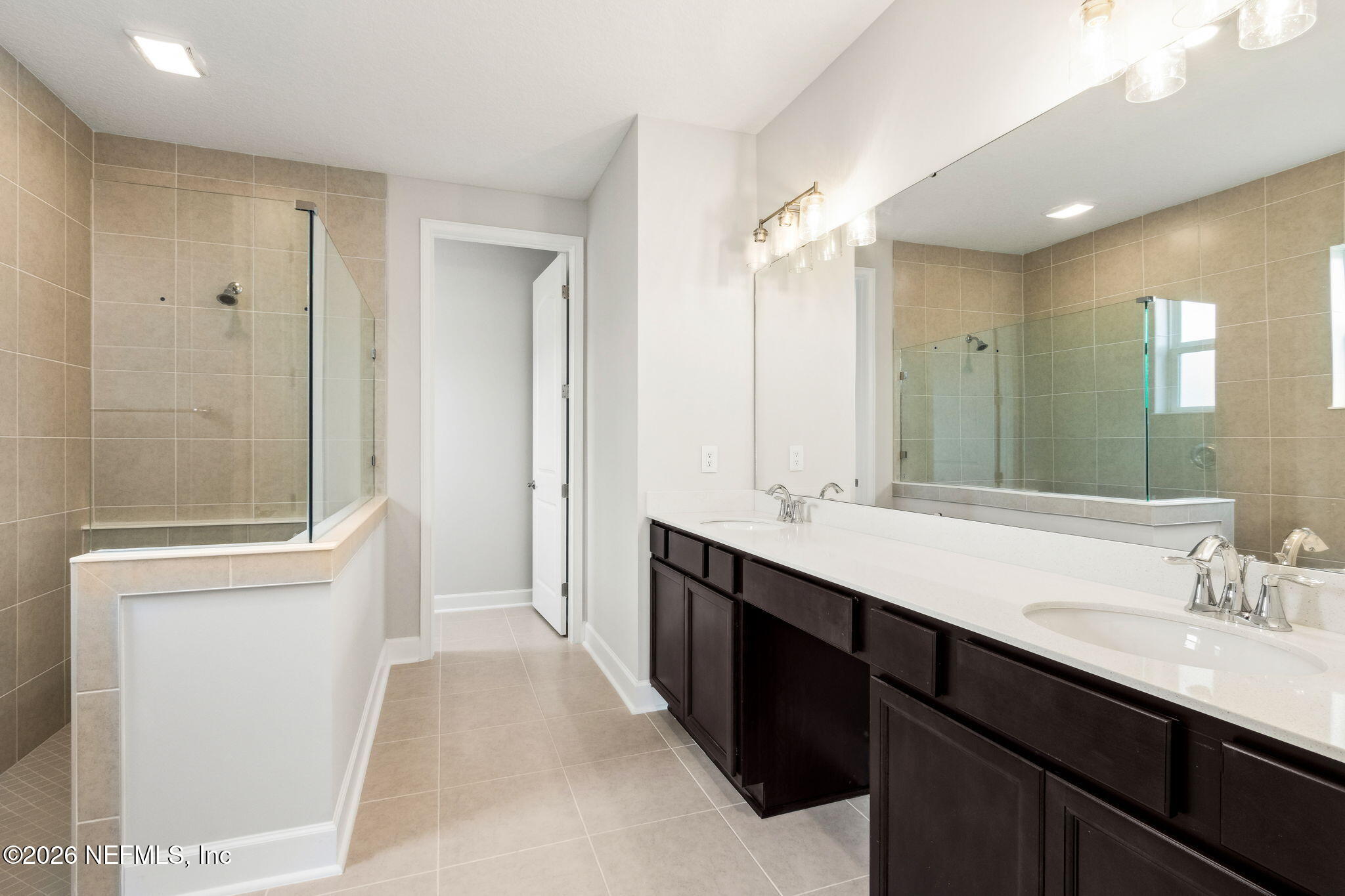 85236 Sandy Rdg Loop, Unit 26 Yulee, FL 32097 - Photo 8 of 17 a spacious bathroom with a double vanity sink a large mirror and a shower