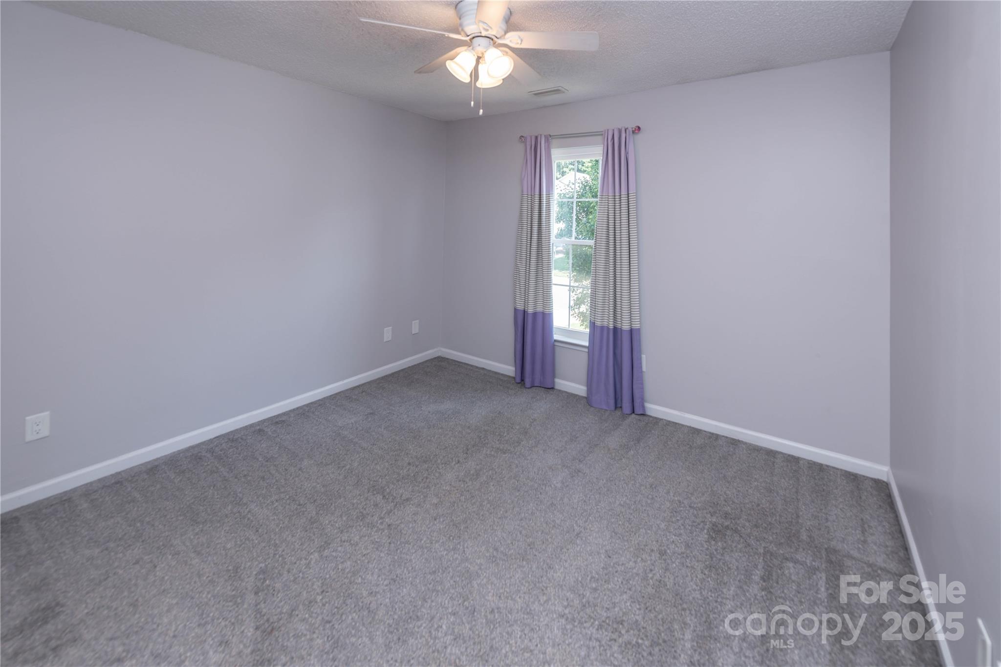 2085 Chapel Creek Road Concord, NC 28025 - Photo 32 of 47 an empty room with chandelier fan and windows