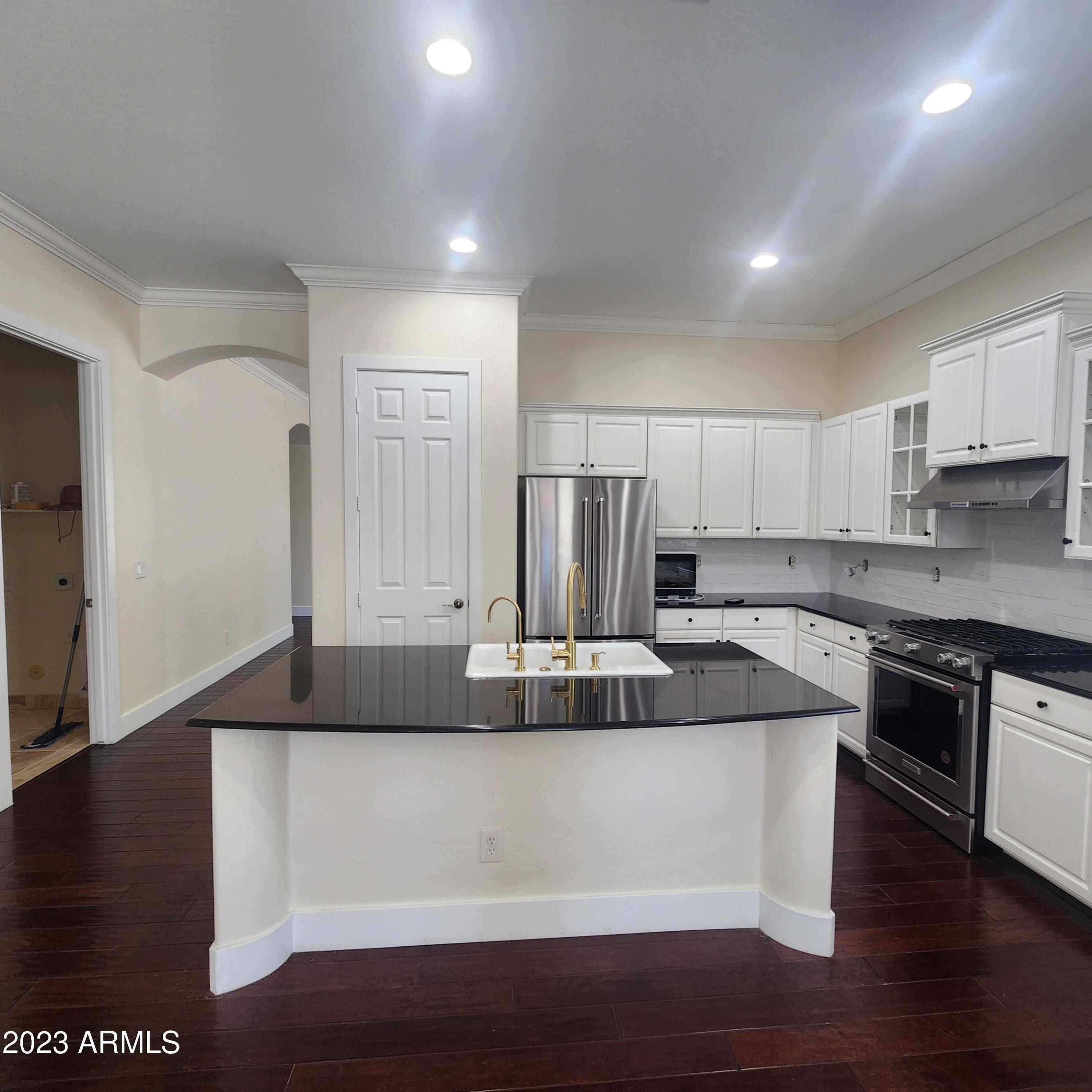 4553 North Point Ridge Road Buckeye, AZ 85396 - Photo 9 of 13 a kitchen with kitchen island granite countertop a sink and refrigerator