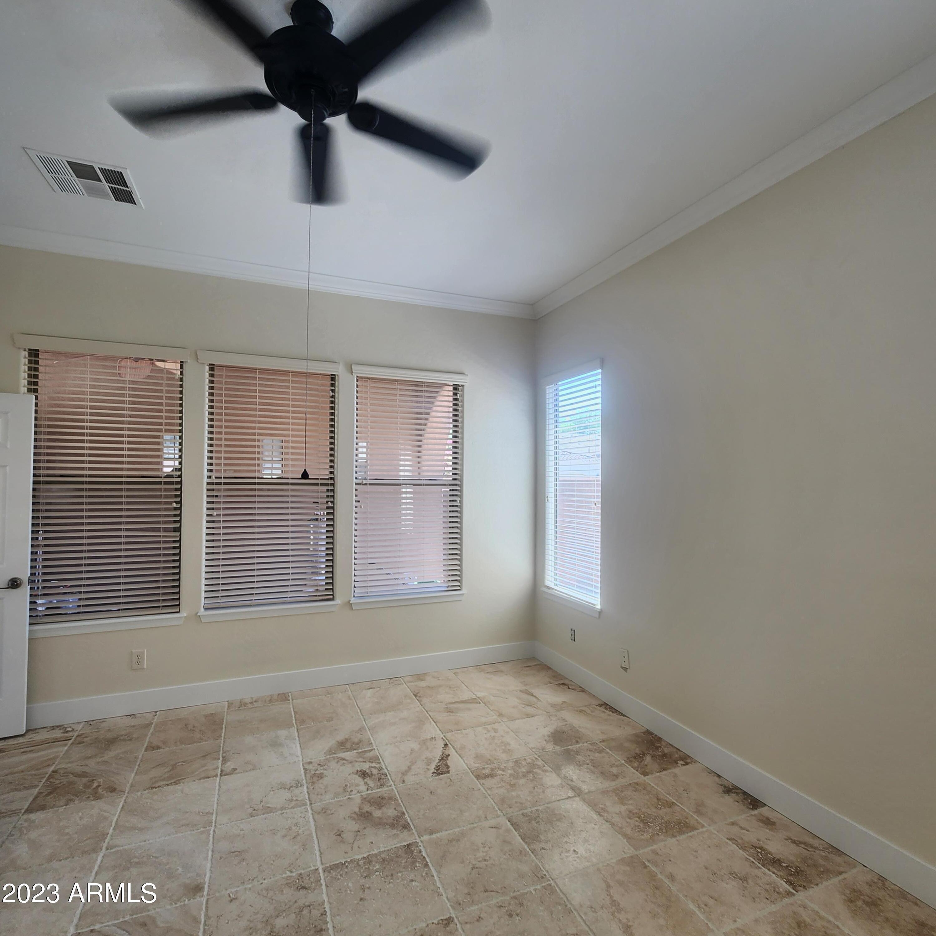 4553 North Point Ridge Road Buckeye, AZ 85396 - Photo 10 of 13 an empty room with windows and ceiling fan