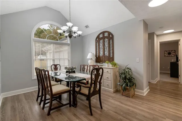 a view of a dining room with furniture a chandelier and wooden floor