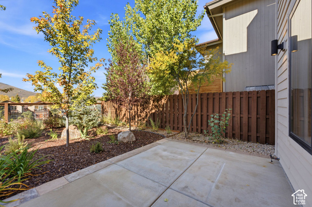 1067 Station Loop Road Park City, UT 84098 - Photo 29 of 38 Concrete patio with privacy fencing, mature trees, and landscaping with natural rock elements