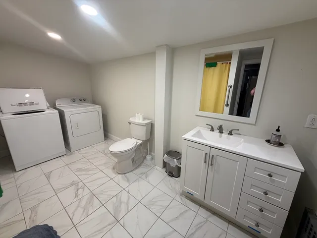 a bathroom with a toilet sink and mirror