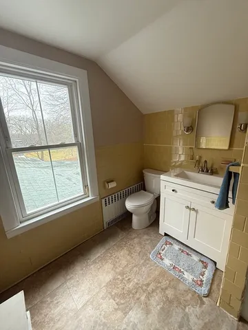 a bathroom with a sink toilet and window
