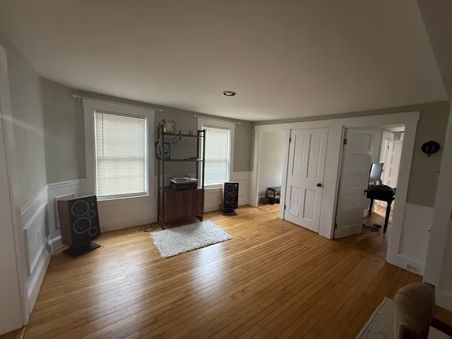 a view of a livingroom with wooden floor and a window