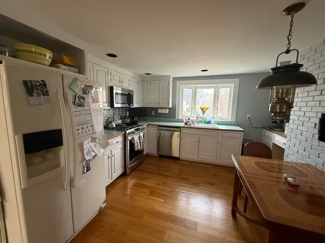 a kitchen with stainless steel appliances a refrigerator sink and cabinets