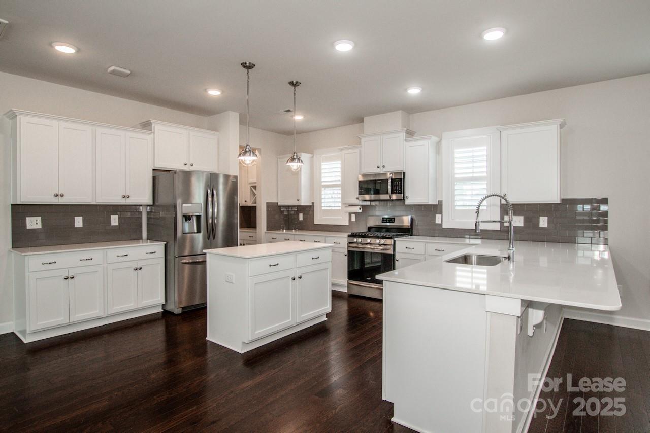 13218 Caite Ridge Road Davidson, NC 28036 - Photo 27 of 48 a kitchen with white cabinets and stainless steel appliances