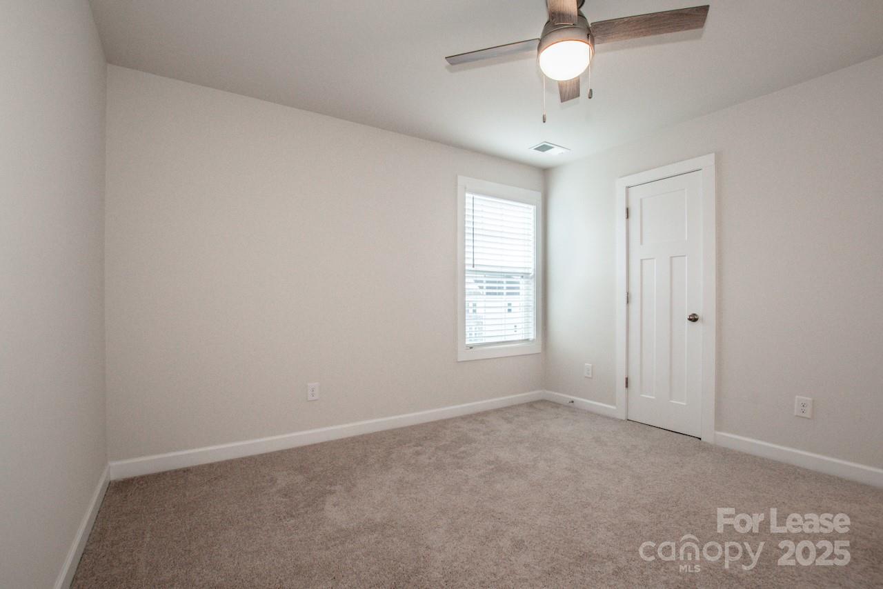 13218 Caite Ridge Road Davidson, NC 28036 - Photo 32 of 48 an empty room with windows and chandelier fan