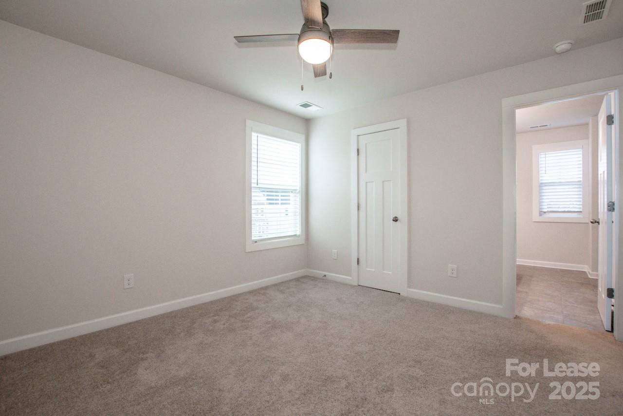 13218 Caite Ridge Road Davidson, NC 28036 - Photo 38 of 48 an empty room with chandelier fan and windows