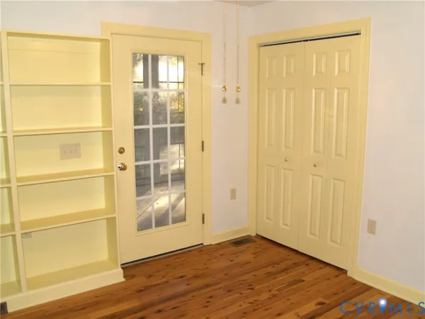 a view of empty room with wooden floor