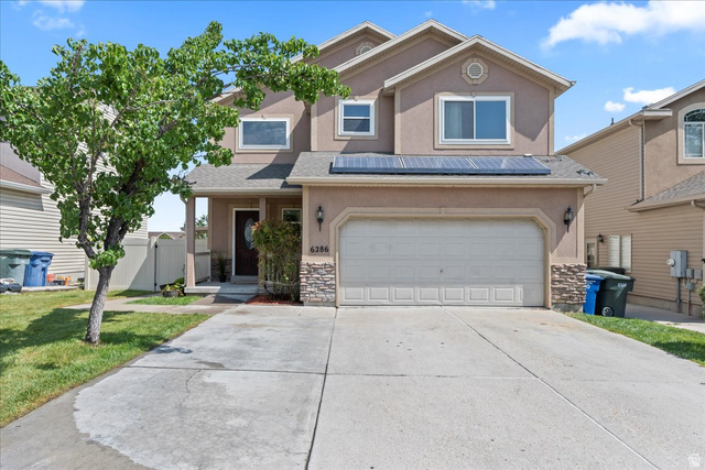6286 Anders Ridge Way West Valley City, UT 84128 - Photo 1 of 1 View of front of house with stucco siding, concrete driveway, stone siding, and a garage