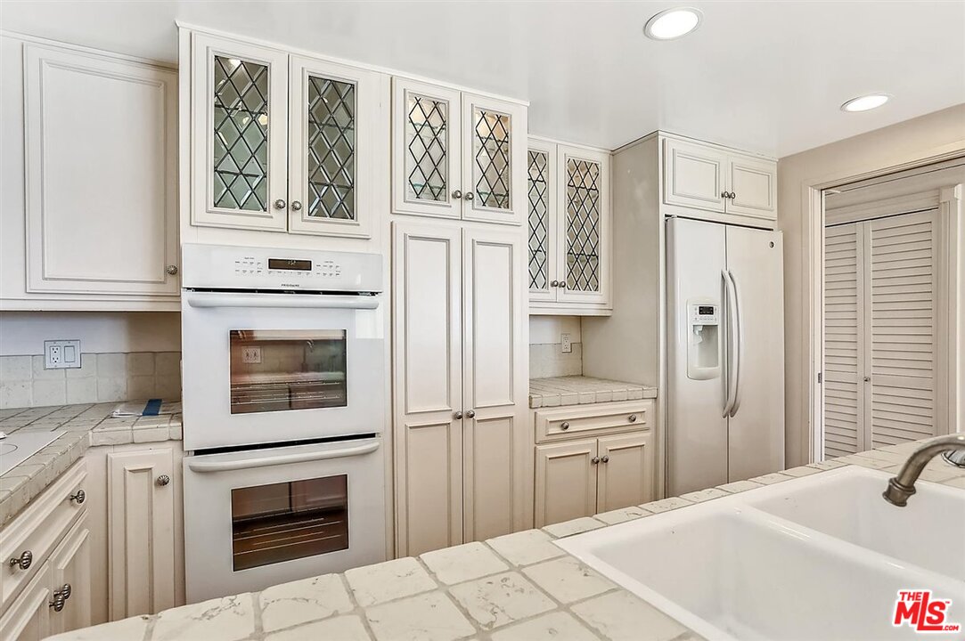 2160 Century Park East, Unit 1903 Los Angeles, CA 90067 - Photo 11 of 40 a kitchen with stainless steel appliances white cabinets and window