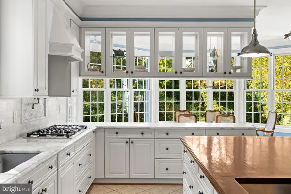 a kitchen with kitchen island granite countertop a sink a counter space appliances and cabinets