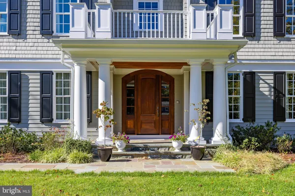 a front view of a house with plants and outdoor seating