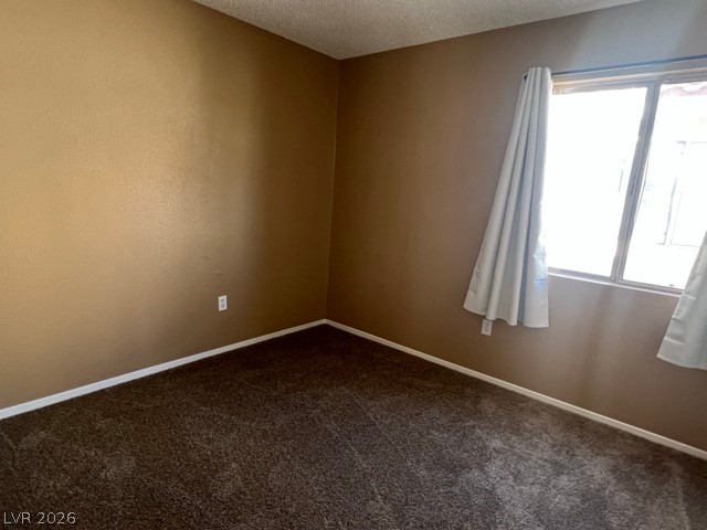 4140 North Compass Rose Way Las Vegas, NV 89108 - Photo 14 of 16 Unfurnished room with dark colored carpet and a textured ceiling