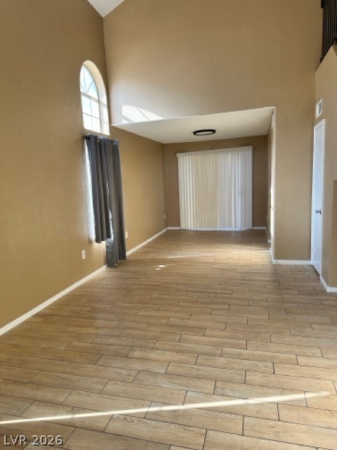 4140 North Compass Rose Way Las Vegas, NV 89108 - Photo 3 of 16 Empty room featuring a high ceiling and wood finish floors