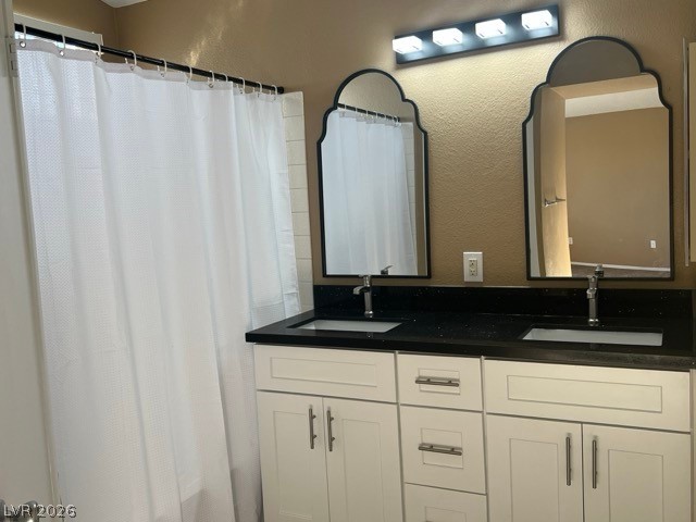 4140 North Compass Rose Way Las Vegas, NV 89108 - Photo 10 of 16 Bathroom with double vanity, a textured wall, and curtained shower