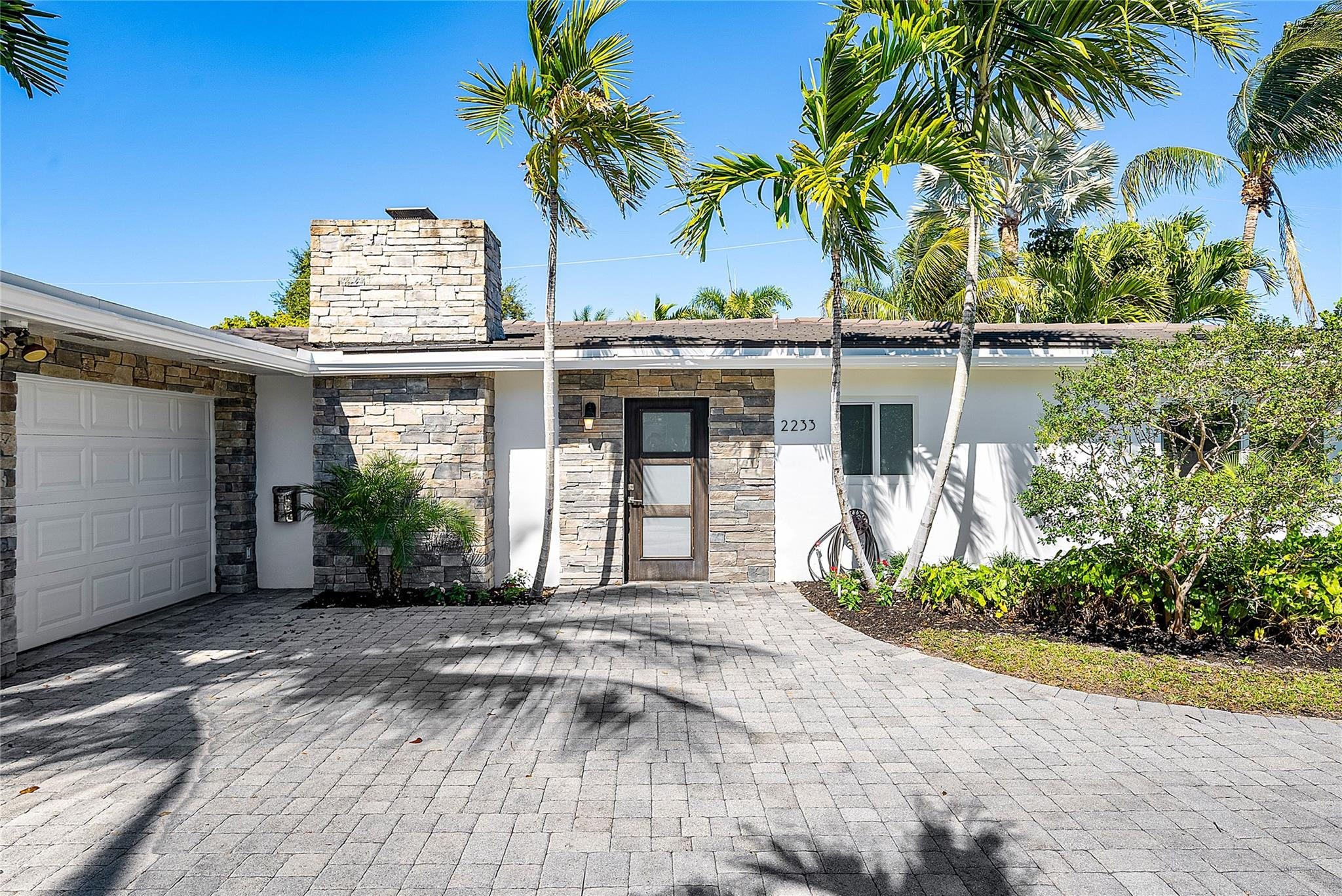 2233 Northeast 30th Court Lighthouse Point, FL 33064 - Photo 2 of 48 a front view of a house with garden