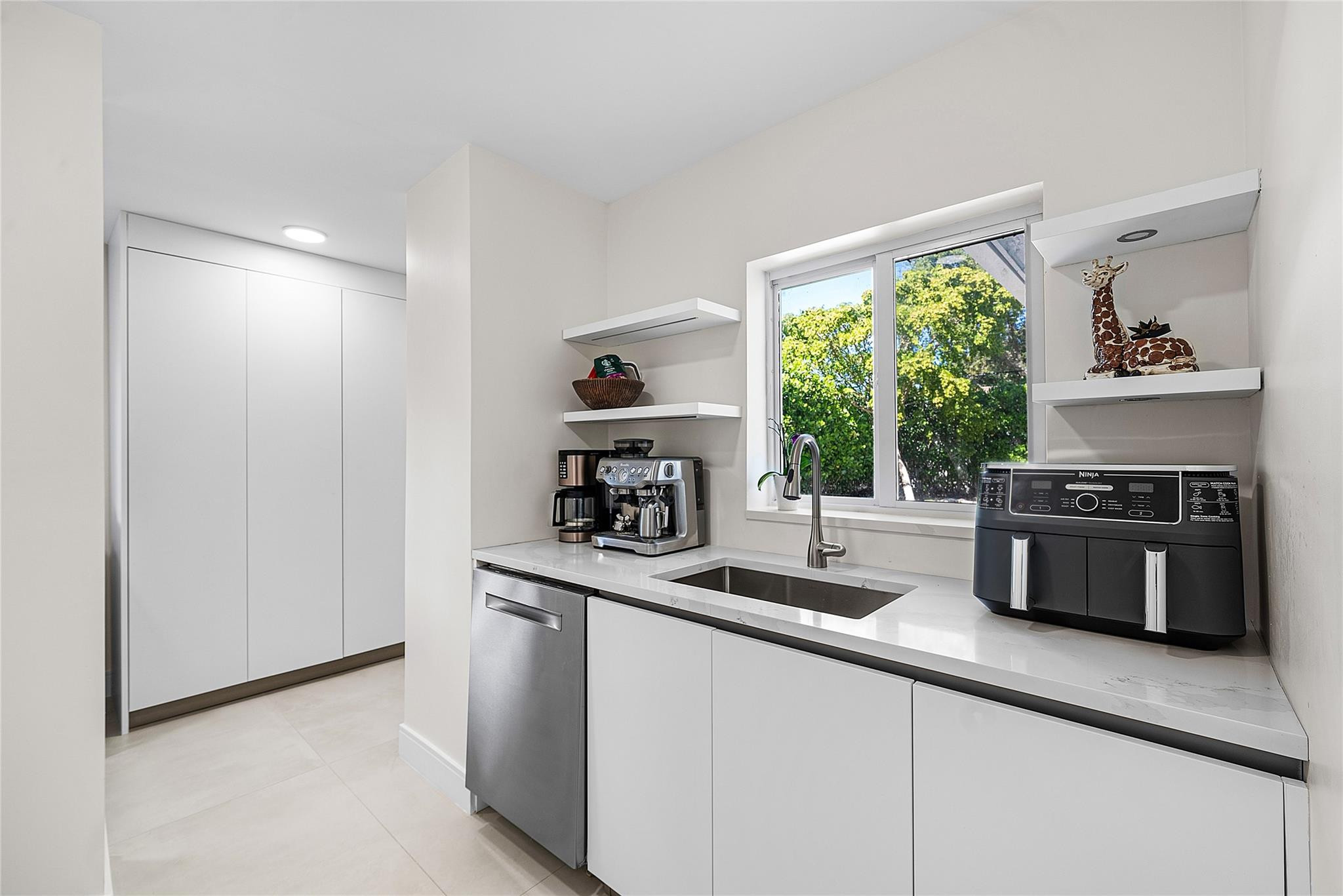 2233 Northeast 30th Court Lighthouse Point, FL 33064 - Photo 30 of 48 a kitchen with stainless steel appliances a sink a stove a microwave and a window