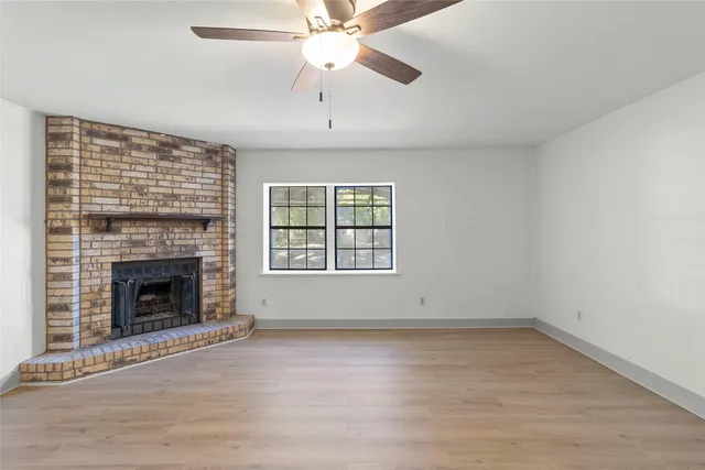 an empty room with windows and fireplace