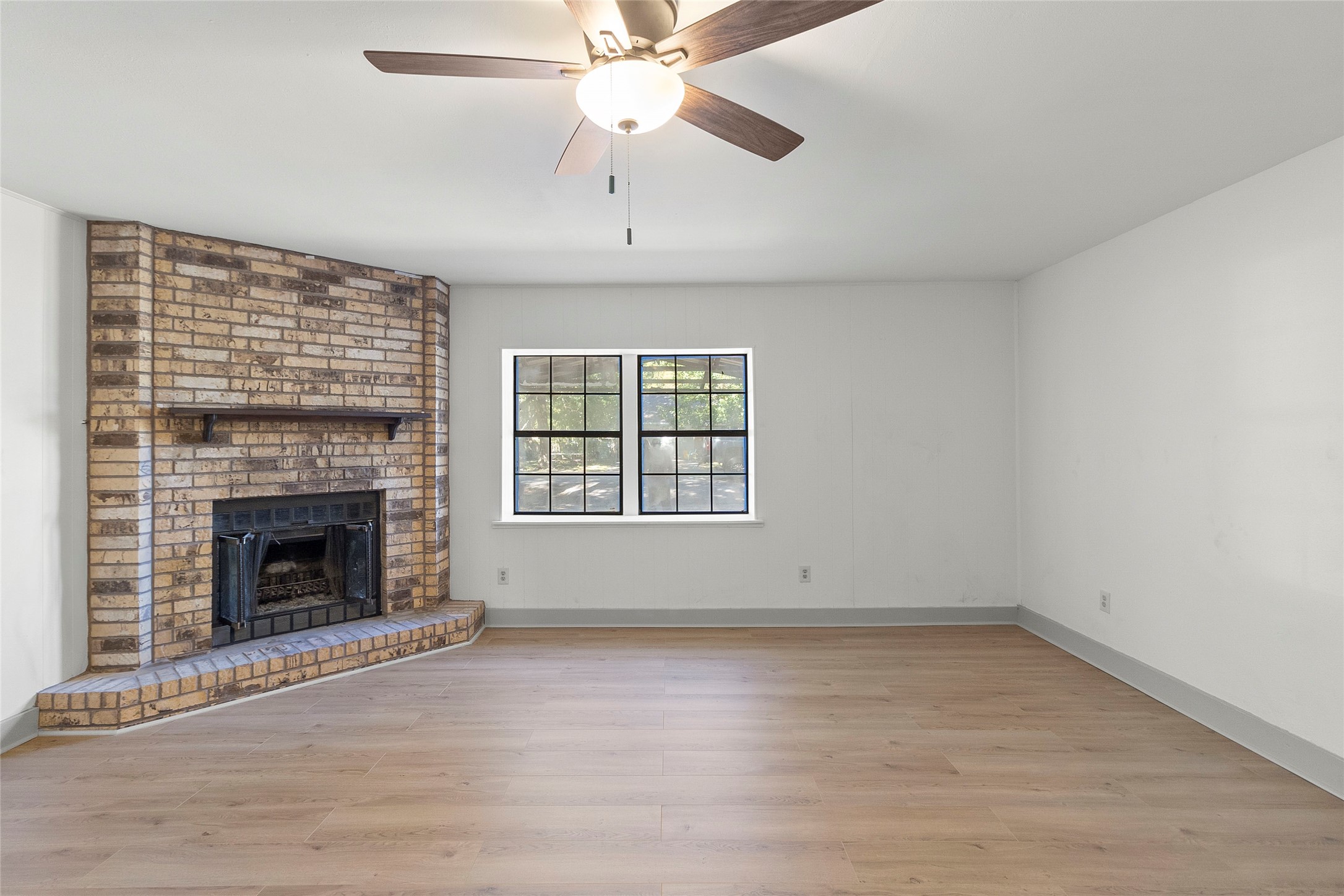 an empty room with windows and fireplace
