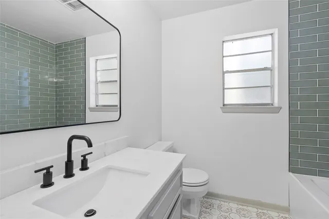 a bathroom with a sink a toilet and a mirror