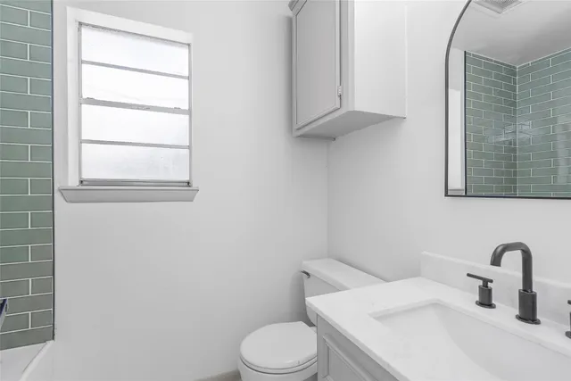 a bathroom with a sink a toilet and window