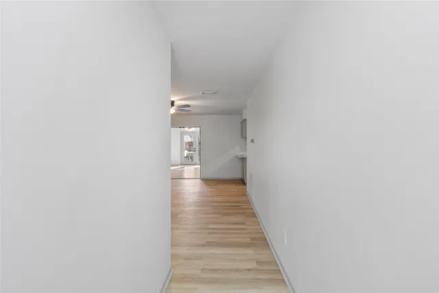 a view of a hallway with wooden floor