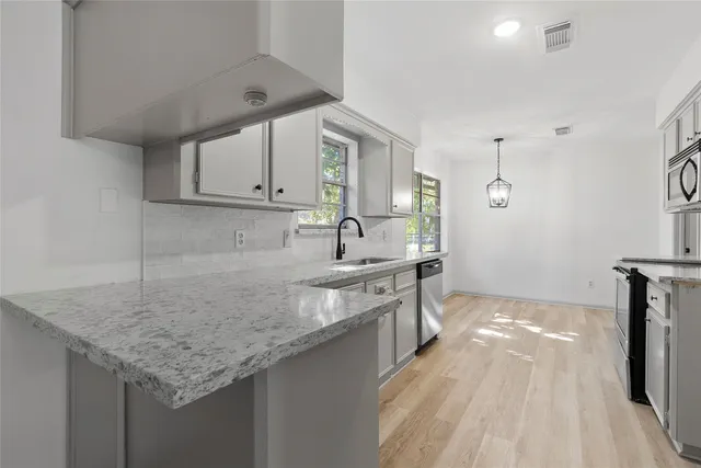 a kitchen with stainless steel appliances granite countertop a sink stove and cabinets