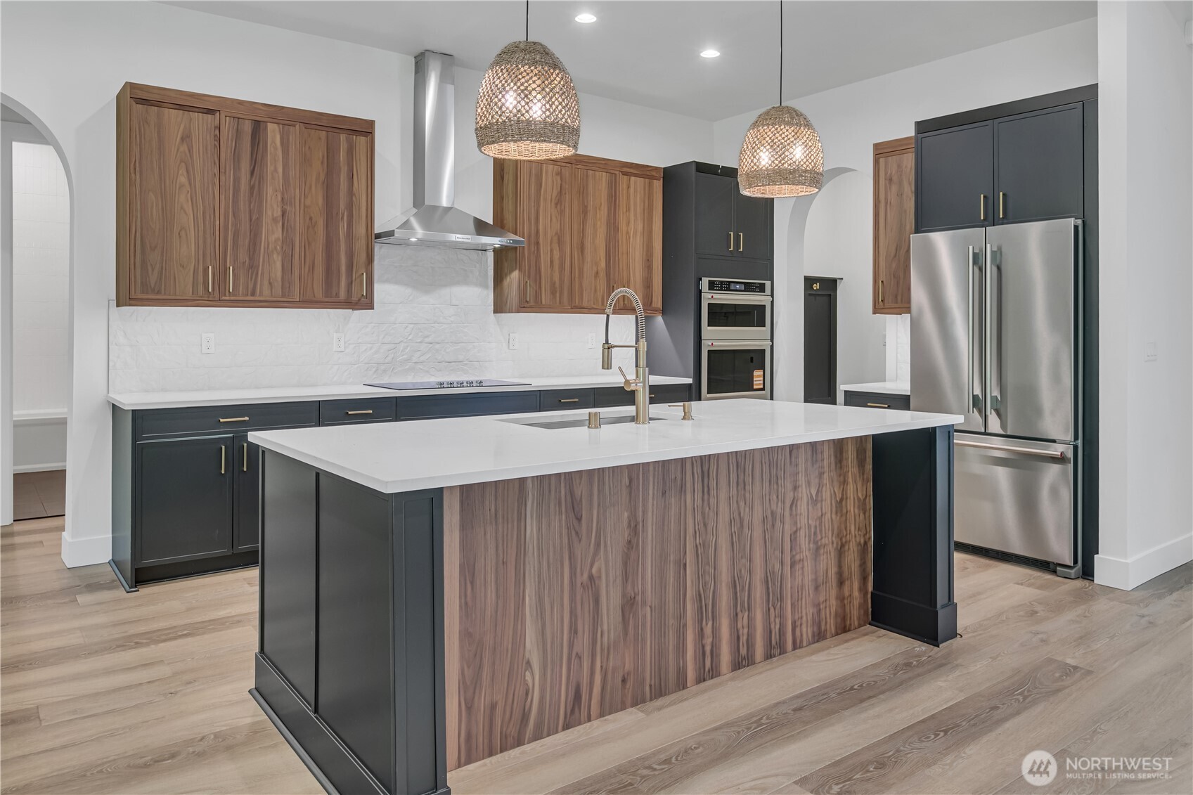 6709 254th Street East Graham, WA 98338 - Photo 11 of 40 a kitchen with stainless steel appliances kitchen island granite countertop a refrigerator a sink and wooden cabinets