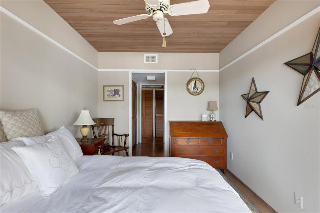 62 Sandy Hook Road South Sarasota, FL 34242 - Photo 19 of 66 a bedroom with a bed and wooden floor