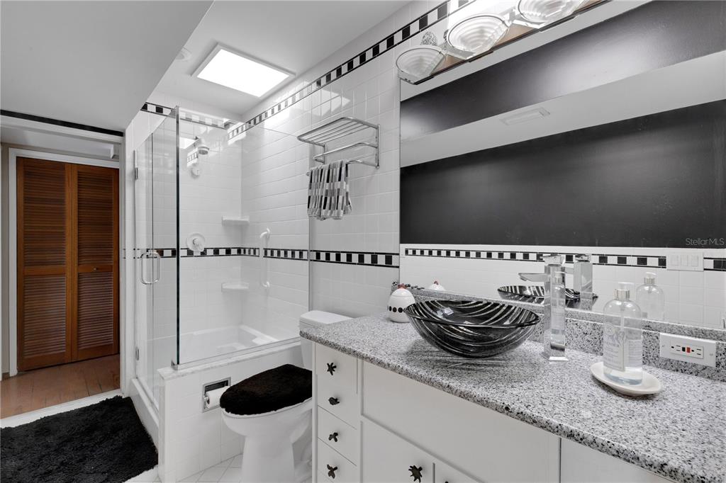 62 Sandy Hook Road South Sarasota, FL 34242 - Photo 23 of 66 a bathroom with a granite countertop sink a toilet and shower