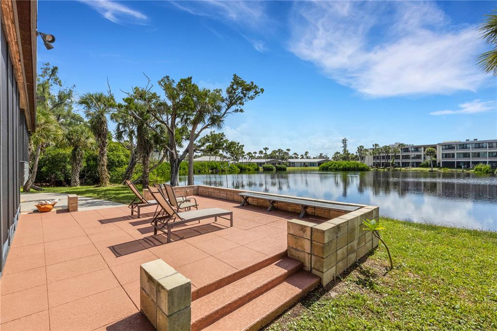 62 Sandy Hook Road South Sarasota, FL 34242 - Photo 40 of 66 a view of a swimming pool with lounge chairs in front of a house