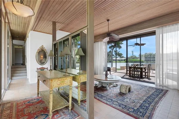 a living room with furniture a rug and a floor to ceiling window