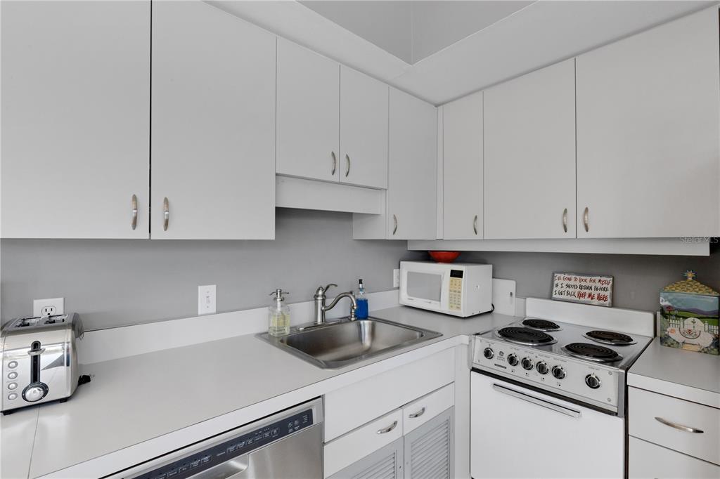 62 Sandy Hook Road South Sarasota, FL 34242 - Photo 52 of 66 a kitchen with white cabinets and appliances