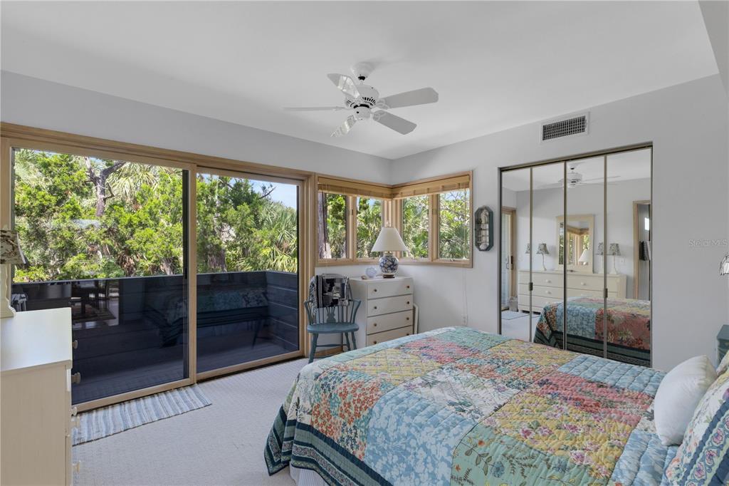 62 Sandy Hook Road South Sarasota, FL 34242 - Photo 54 of 66 a bedroom with a balcony a bed and a large window