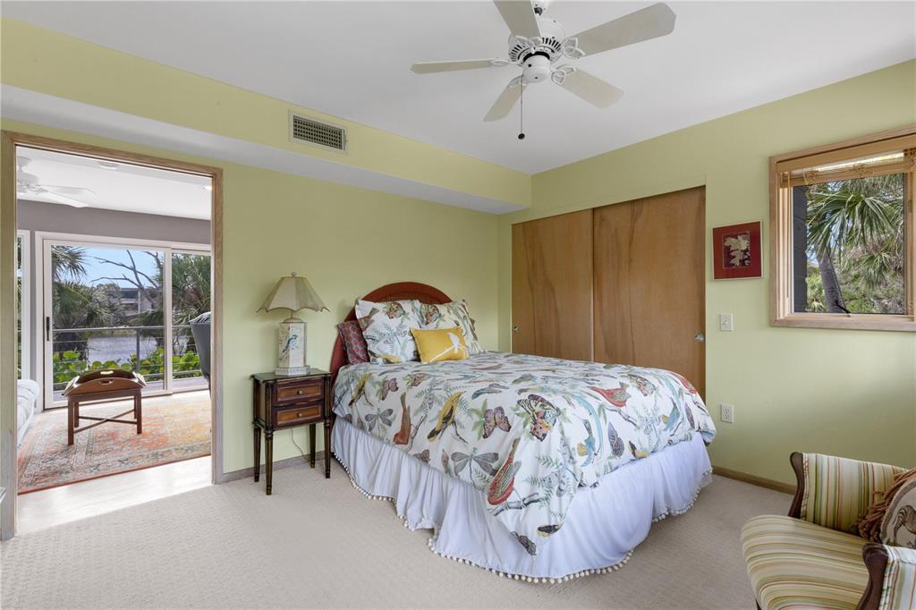 62 Sandy Hook Road South Sarasota, FL 34242 - Photo 59 of 66 a bedroom with a bed and a chandelier