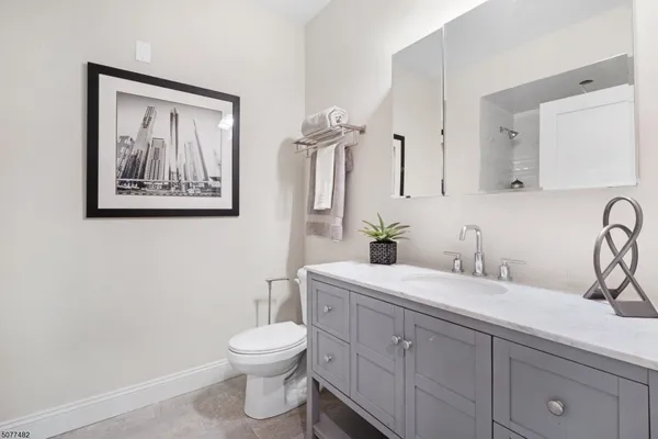 a bathroom with a toilet a sink and mirror