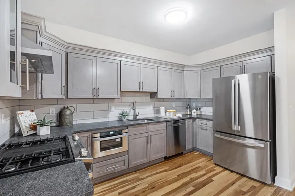 a kitchen with stainless steel appliances granite countertop a stove a refrigerator and a sink