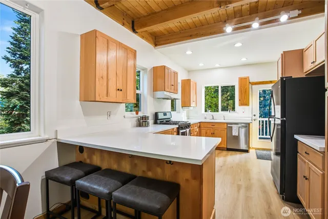 a kitchen with a table chairs refrigerator and microwave