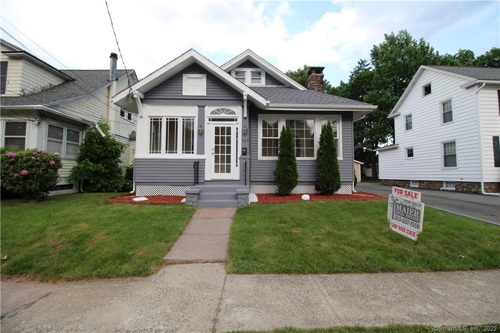 a front view of a house with a yard and trees