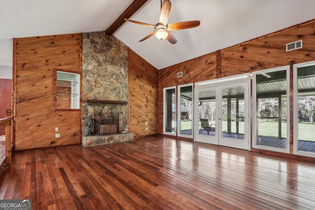 a view of a livingroom with wooden floor and a fireplace